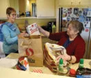 Carol Harper, left, of the Companions Club, helps resident Sharon Noteboom put away her groceries. - Rossmoor Walnut Creek