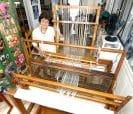 Woman standing at a loom.